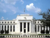 Gedung Eccles kantor pusat Federal Reserve berfasad putih dengan bendera Amerika Serikat