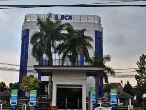 Gedung kantor Bank Central Asia empat lantai dengan pohon palem di halaman depan