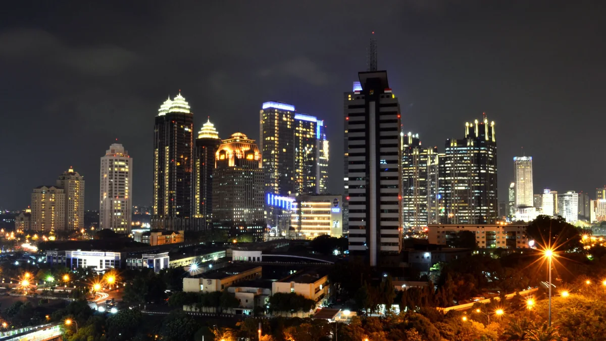 Gedung perkantoran tinggi kawasan SCBD Jakarta dengan lampu menyala pada malam hari