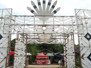 Gerbang berornamen belah ketupat putih dan hitam menuju lokasi Festival Budaya Dayak Deah 2025