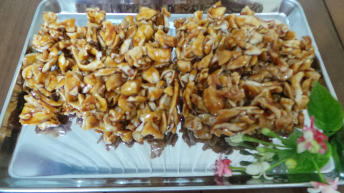 Halua kenari bersalut gula aren tersusun di atas nampan logam