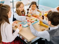 Sekelompok anak duduk semeja menyantap makanan di kantin sekolah
