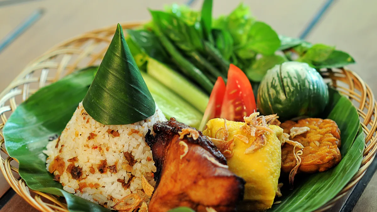 Hidangan khas Sunda di Bandung dengan nasi, lauk, dan lalapan di atas daun pisang