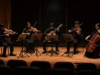 Ilustrasi gitaris klasik diapit dua biola, viola, dan selo di panggung resital