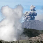 Ilustrasi gunung api yang tengah erupsi dengan kepulan asap tebal