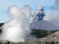 Ilustrasi gunung api yang tengah erupsi dengan kepulan asap tebal