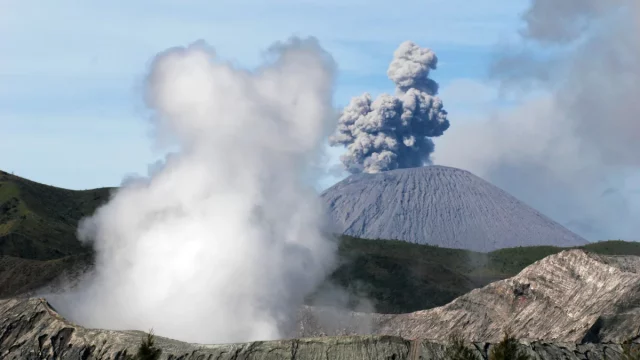 Ilustrasi gunung api yang tengah erupsi dengan kepulan asap tebal