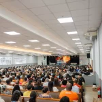 Ilustrasi peserta memenuhi ruang auditorium pada sebuah kuliah umum kampus