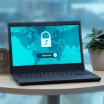 Ilustrasi laptop menampilkan ikon gembok keamanan di atas meja bundar