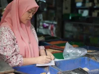 Ilustrasi pedagang pasar mencatat penjualan harian di kiosnya