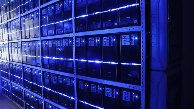 Ilustrasi deretan rak server dengan lampu indikator biru di sebuah pusat data