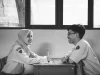 Ilustrasi dua pelajar berbincang di ruang kelas