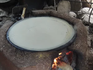 Adonan injera dipanggang di atas mitad tanah liat di tungku batu, Etiopia
