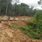 Iring-iringan mobil melintasi ruas jalan tanah berlumpur di tengah hutan Papua Barat