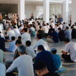 Ilustrasi jemaah laki-laki duduk berbaris di dalam ruang masjid
