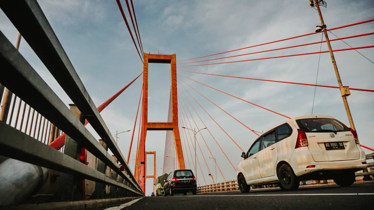 Kendaraan melintas di atas Jembatan Suramadu dengan kabel penyangga berwarna merah