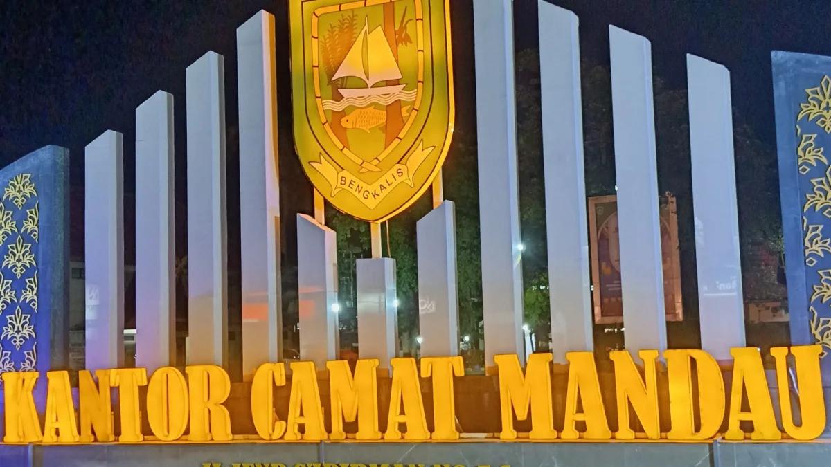Tugu nama Kantor Camat Mandau dengan lambang Kabupaten Bengkalis pada malam hari
