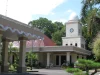 Gedung Balai Kota Mataram bermenara jam putih dengan pohon palem di halaman