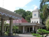 Gedung Balai Kota Mataram bermenara jam putih dengan pohon palem di halaman