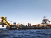 Kapal penunjang lepas pantai dengan derek kuning di tengah laut
