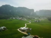 Pemandangan udara bukit-bukit karst, sawah, dan permukiman di kawasan Rammang-Rammang