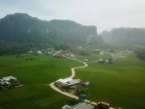 Pemandangan udara bukit-bukit karst, sawah, dan permukiman di kawasan Rammang-Rammang