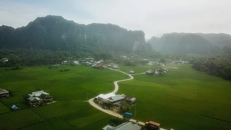 Pemandangan udara bukit-bukit karst, sawah, dan permukiman di kawasan Rammang-Rammang