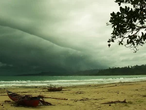 Awan badai menggantung di atas Pantai Lasikin, Pulau Simeulue, dengan perahu di pasir