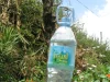 Botol air bergagang digantung terbalik di dahan pohon sebagai keran cuci tangan sederhana