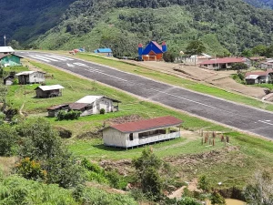 Lapangan terbang perintis dan permukiman beratap seng di lembah Kiwirok, Pegunungan Bintang, Papua