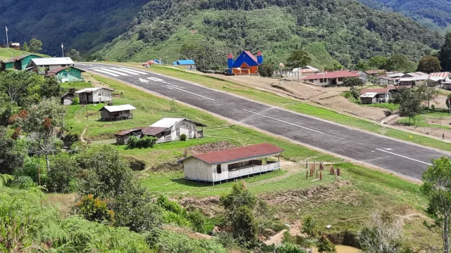 Lapangan terbang perintis dan permukiman beratap seng di lembah Kiwirok, Pegunungan Bintang, Papua