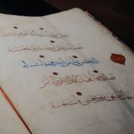 Ilustrasi halaman naskah berhuruf Arab dengan kaligrafi dan cap merah.