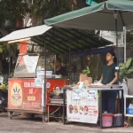Ilustrasi pedagang kaki lima berdiri di lapaknya di tepi jalan