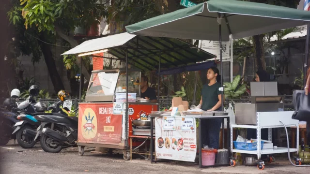Ilustrasi pedagang kaki lima berdiri di lapaknya di tepi jalan