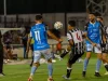 Para pemain sepak bola berduel dalam pertandingan malam di bawah lampu stadion