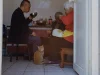 Pria dan perempuan lanjut usia makan bersama di dapur rumah dengan kucing di lantai