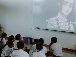 Ilustrasi murid-murid berseragam menonton tayangan dari proyektor di dalam kelas.