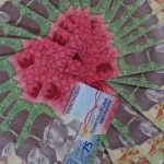Lembaran uang rupiah pecahan lima ribu dan tujuh puluh lima ribu tersusun melingkar