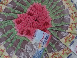 Lembaran uang rupiah pecahan lima ribu dan tujuh puluh lima ribu tersusun melingkar