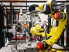 Lengan robot kuning bekerja di fasilitas produksi