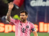 Lionel Messi melambaikan tangan di lapangan