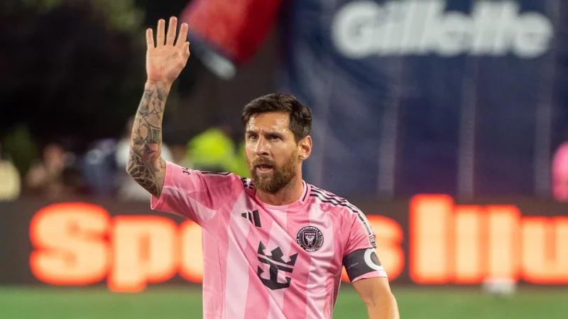 Lionel Messi melambaikan tangan di lapangan