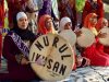 Ilustrasi sekelompok perempuan berjilbab memainkan rebana dalam busana berwarna merah dan ungu.