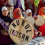 Ilustrasi sekelompok perempuan berjilbab memainkan rebana dalam busana berwarna merah dan ungu.
