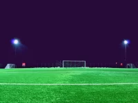 Pemain sepak bola menggiring bola di lapangan