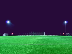 Pemain sepak bola menggiring bola di lapangan