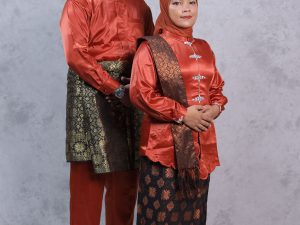 Ilustrasi sepasang orang mengenakan busana songket merah lengkap dengan penutup kepala.