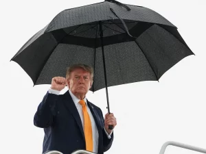 Presiden Amerika Serikat Donald Trump mengepalkan tangan saat menaiki Air Force One di Pangkalan Gabungan Andrews, Maryland.