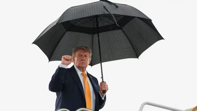 Presiden Amerika Serikat Donald Trump mengepalkan tangan saat menaiki Air Force One di Pangkalan Gabungan Andrews, Maryland.