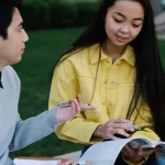 Dua mahasiswa belajar bersama di lingkungan kampus